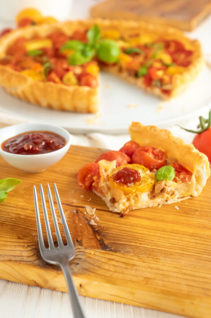 Die Tomatentarte mit einer pikanten Füllung aus Tomaten,  Käse und Zwiebel. Schmeckt mit einem Klescks Tomatenmarmelade noch umso besser.