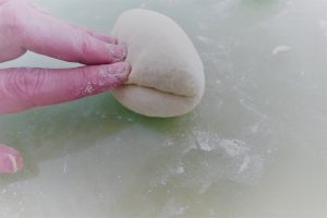 Weizenbrötchen mit Falte zusammendrücken