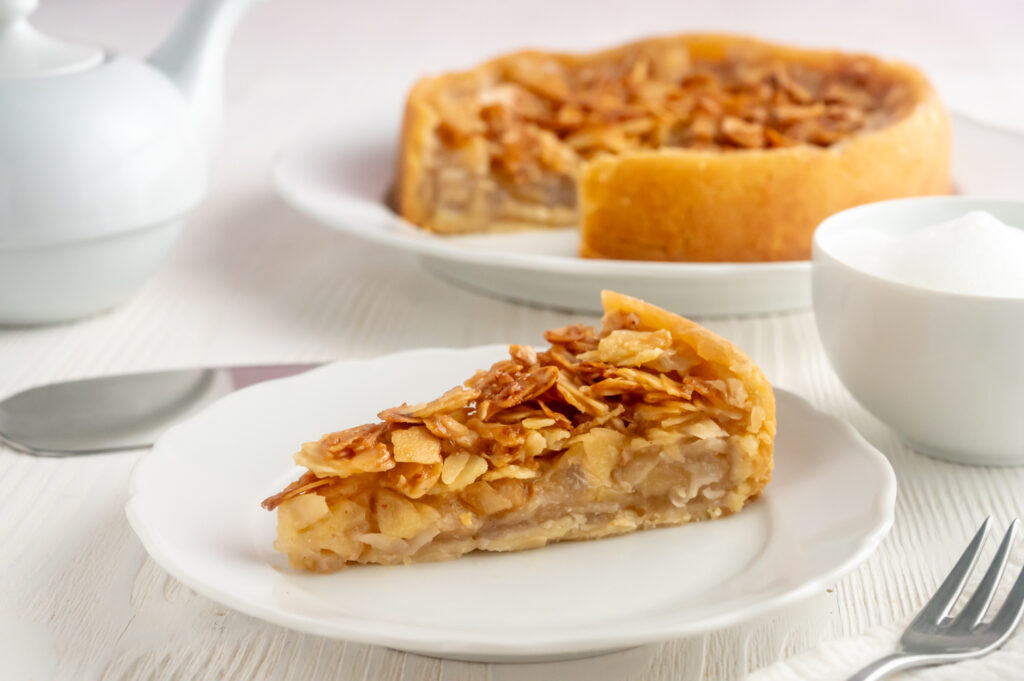 Einfacher Apfelkuchen mit Mandeln. Mit einer knusprigen Mandelschicht wie beim Bienenstich. Leicht umhüllt von einem dünnen Teig, gefüllt mit Apfelstückchen.