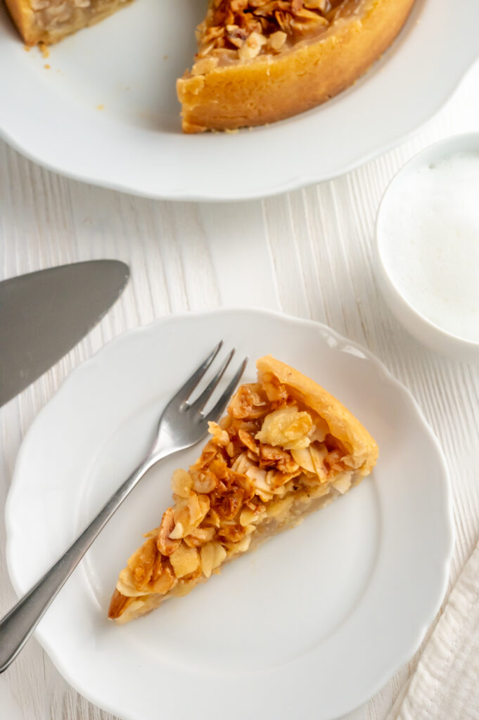 Eine knusprige Mandelschicht wie beim Bienenstich, leicht umhüllt von einem dünnen Teig, gefüllt mit Apfelstückchen. Entdecke mein Rezept für den einfachen Apfelkuchen mit Mandeln.