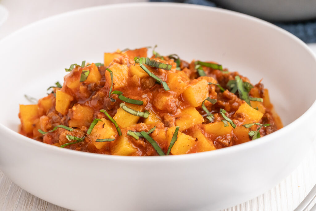 Kartoffel-One-Pot mit Hackflesich und Tomatensauce. garniert mit fein geschnittenem Basilikum.